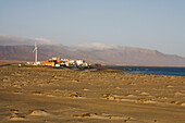 Sand und das Dorf Puertito de la Cruz an der Küste, Parque Natural de Jandia, Halbinsel Jandia, Fuerteventura, Kanarische Inseln, Spanien, Europa
