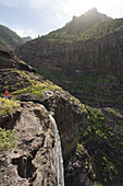 Wanderer im Gebirge am Wasserfall Cascada El Palmar, Tal von El Risco, Naturpark Tamadaba, Gran Canaria, Kanarische Inseln, Spanien, Europa