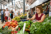 Woman selling fresh vegetables on the market, Loule market hall, Loule, Algarve, Portugal
