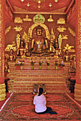 Woman praying to Buddha, Wat Phra Kaeo, Chiang Rai, Golden Triangle, Thailand, Asia