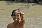 Kind beim Fischfang in schlammigem Graben, Lopburi, Zentralthailand, Thailand, Asien