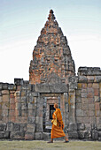 Monk walking past Prang, Prasat Hin Khao Phanom Rung, Khmer Temple in Buriram province, Thailand, Asia