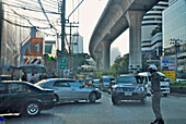 Verkehr auf der Sukhumvit, Verkehrspolizist leitet den Verkehr unter der Hochbahn, Sukhumvit, Bangkok, Thailand, Asien