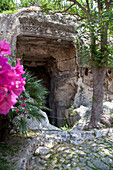 Grotta della Vipera, entrance of the viper grotto in the shadow of trees, Cagliari, Sardinia, Italy, Europe