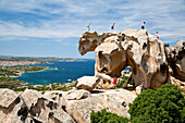 Tourists on a bear shaped rock formation, Capo d'Orso, Palau, Sardinia, Italy, Europe