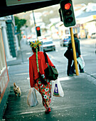 Passantin mit Einkaufstüten vor roten Ampeln, kreatives Viertel Cuba Street, Wellington, Nordinsel, Neuseeland