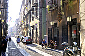 Menschen in einer sonnenbeschienenen Strasse, Bosa, Sardinien, Italien, Europa