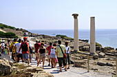 Tourists in front of roman excavation in the sunlight, antique town Tharros, Sardinia, Italy, Europe