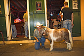 Mann mit seinem Haustier vor einem Club auf der Bourbon street, French Quarter, New Orleans, Louisiana, Vereinigte Staaten, USA