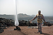 Demonstratiob of an artifical geyser by volcanic heat, park ranger, Parque Nacional de Tiimanfaya, Montanas del Fuego, UNESCO Biosphere Reserve, Lanzarote, Canary Islands, Spain, Europe