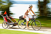 Cyclist with child trailer, Lake Starnberg, Bavaria, Germany