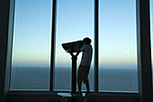 A child looks through binoculars from the top of Q1 building in Surfers Paradise,  Gold Coast,  Australia