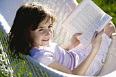 Girl reading a book on a hammock