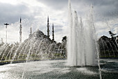 fountain and blue mosque in background