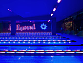 neon light falling on empty bowling lanes with hollywood sign.