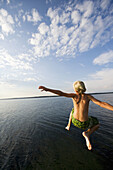 Boys leaping off a pier in Denmark