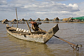 Fishing boat and beach with huts on the island Koh Deik in the Mekong River, Cambodia, Asia