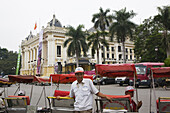 Rickshaw driver in front of the opera at Hanoi, Ha Noi Province, Vietnam, Asia