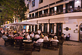 Menschen sitzen abends vor dem Golden Gate Grand Café, Funchal, Madeira, Portugal
