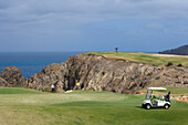 Golfer chipping ball from the green of Hole 15 at Porto Santo Golfe Golf Course, Porto Santo, near Madeira, Portugal