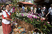 Frau verkauft Blumen beim alljährlich stattfindenden Madeira Blumenfest, Funchal, Madeira, Portugal