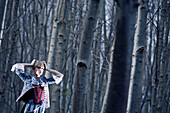 Young woman wearing a dirndl, traditional costume, standing in a forest, Kaufbeuren, Bavaria, Germany