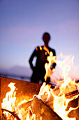 Fireplace, man in background, lake Worthsee, Bavaria, Germany