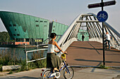 Bike Ride By The Science Center 'Nemo', Similar To A Green Vessel, A Work By The Architect Renzo Piano, Amsterdam, Netherlands
