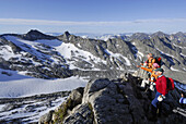 Three mountain hikers enjoying view at mount Hochfeiler, Zillertal Alps, South Tyrol, Italy