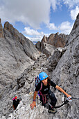 Girl climbing at Sass Rigais, Geisler range, Dolomites, Trentino-Alto Adige/South Tyrol, Italy