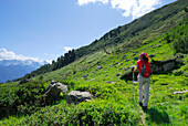 Woman hiking along trail, Valle Santa Maria, Ticino Alps, Canton of Ticino, Switzerland