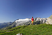 Frau wandert über Wiese, Basodinogletscher im Hintergrund, Tessiner Alpen, Tessin, Schweiz