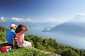 Couple looking over Lake Como, Monti Lariani, Lombardy, Italy