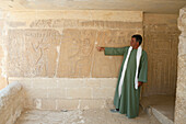 Guide shows Inscription at Mastaba near Saqqara Step Pyramid of Pharaoh Djoser, Egypt, Saqqara