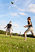 Young people playing volleyball on a meadow, Leipzig, Saxony, Germany