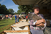 man holding rabbit at the horse and pet market in Burgdorf, Lower Saxony, northern Germany