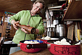 Woman preparing fondue, Albert Heim mountain lodge, Urner Alps, Canton of Uri, Switzerland