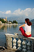 Woman enjoying view over Lake Como to Tremezzo, Lombardy, Italy