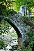 Frau geht über Steinbrücke mit Bildstock, Via Dei Monti Lariani, Comer See, Tessiner Alpen, Lombardei, Italien