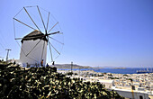 Windmill and view of the town in the sunlight, island of Mykonos, the Cyclades, Greece, Europe