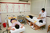 Ein Arzt behandelt zwei Patienten, Xiamen, Fujian Provinz, China, Asien