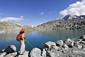 Frau steht bei einem Bergsee, Cima Presena, Presanellagruppe, Trentino-Südtirol, Italien