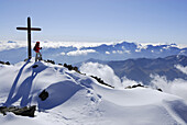 Woman at summit cross of Monte Vioz, Ortler range, South Tyrol, Italy