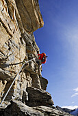 Woman climbing fixed rope route through Tschenglser Hochwand, Ortler range, South Tyrol, Italy