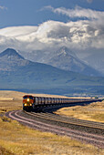 Freight train on the Montana plains near the Rocky Mountain Front Ranges of Glacier National Park USA