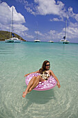 Woman floating on an inflatable tube  Salt Whistle Bay in St Vincent and the Grenadines  Model released
