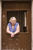 Portuguese woman who lives next to the Bica Elevator tour in the district of Santa Catarina in the extreme southwest of the High Neighborhood in Lisbon,  Portugal