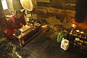 A monk chanting in a smoky room Tiksey,  Ladakh,  India
