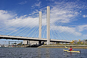 Woman sea kayaking by the Highway 509 bridge,  Tacoma,  Washington