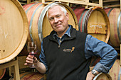 Proud winemaker in barrel room of winery